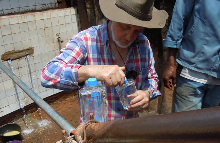 homme en train de remplir des gourdes d'eau potable
