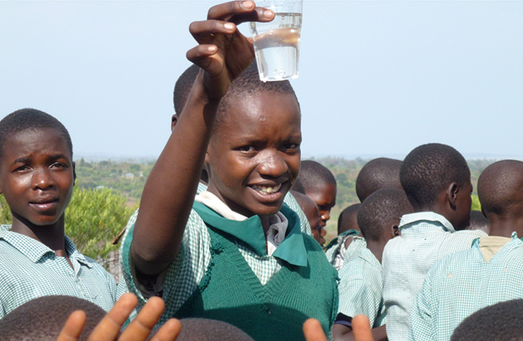 Fille levant son verre d'eau